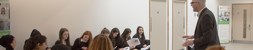 school pupils listening to lecture on campus